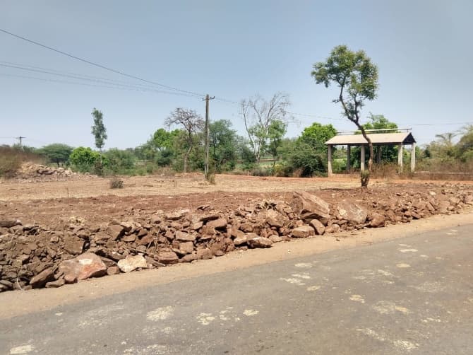 Bare, levelled ground beside a village road.