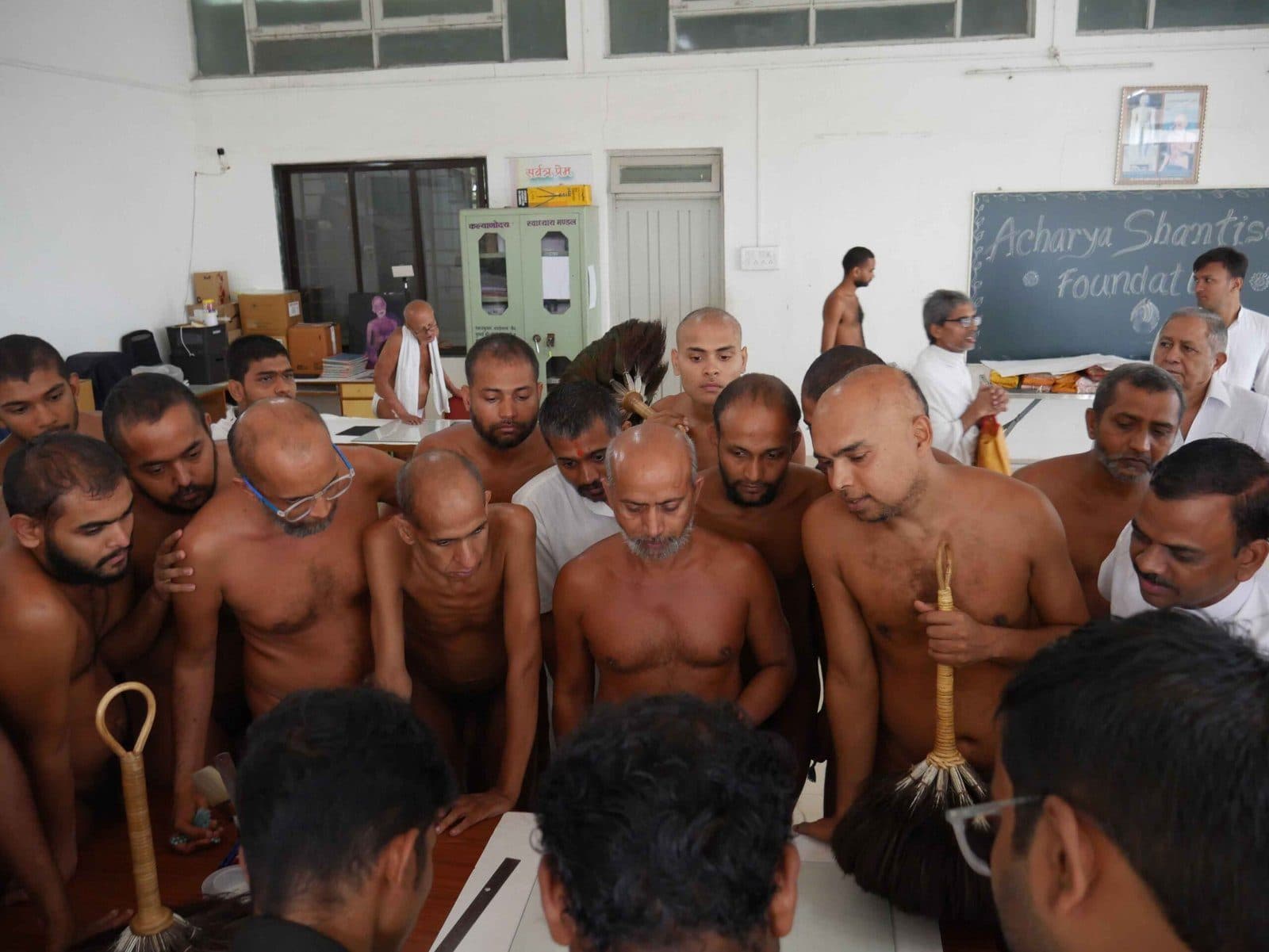 A large group of munis gathered close around a conservation table.